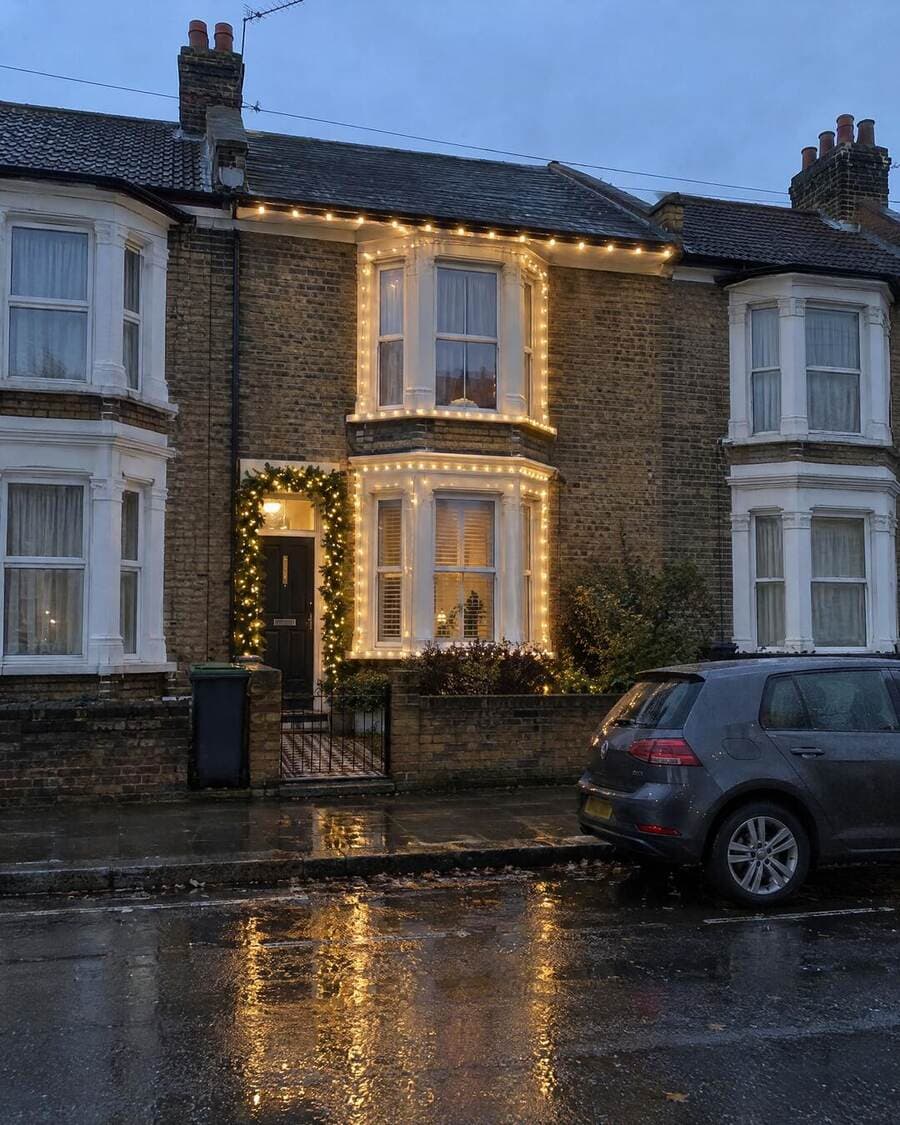 Warm-white Christmas lights on a Victorian terraced house in London